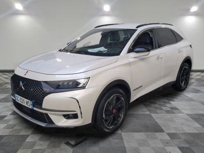 un SUV DSX blanc garé dans un showroom au sol carrelé