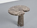 a small table with a stone top on a grey floor
