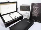 a box with a watch inside of it next to a book