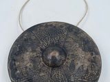 an old metal object on a white surface with a rope