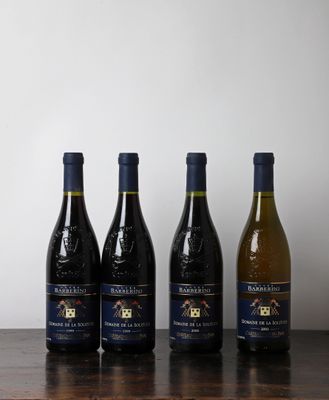 quatre bouteilles de vin sont alignées sur une table en bois