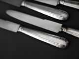 five knives on a table with a black background