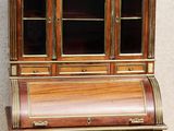 a small wooden desk with a glass door on top of it