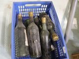 six bouteilles de vin dans un panier bleu posé sur une table