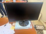 un écran d'ordinateur posé sur un bureau en bois