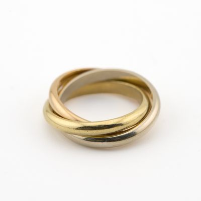 gros plan d'une bague en or et en argent sur une surface blanche