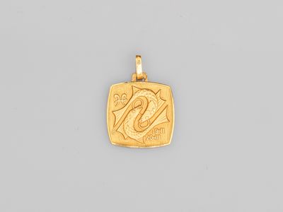 un pendentif en or sur lequel est gravé le chiffre vingt