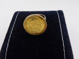 an image of a gold coin sitting on top of a black velvet case