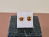 a pair of earrings sitting on top of a marble block