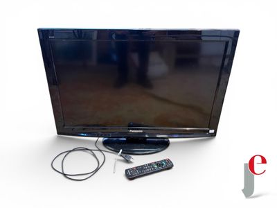 une télévision à écran plat posée sur une table à côté d'une télécommande