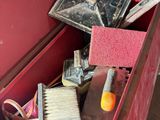 a red box filled with assorted tools and a brush