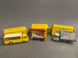 Quatre camions miniatures sont alignés en rang sur une table