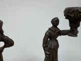 pair of bronze figurines of a woman holding a vase