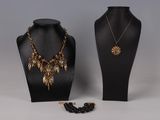 un mannequin noir portant un collier et des boucles d'oreilles