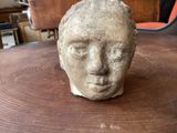 a stone head sitting on a table in a room