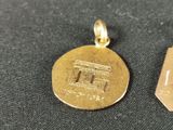 a gold coin and a small gold medal on a table