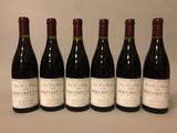 six bouteilles de vin sont alignées sur une table