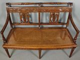 a wooden bench with a wicker seat on top of it