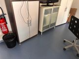 a room with a fire extinguisher, a cabinet, a chair and a fire extinguisher