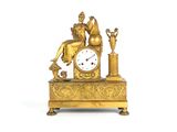 une horloge en or surmontée d'une statue