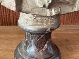 a statue of a man with a hat on top of a wooden table