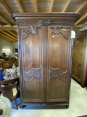 une armoire en bois avec des sculptures dans une pièce