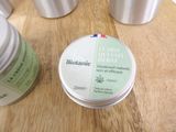 a jar of lotion sitting on a table next to a container of lotion