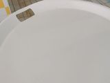 a white toilet in a bathroom with a tiled floor