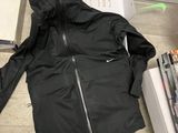 a black jacket sitting on the floor next to a pile of books