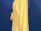 a yellow sweater on a mannequin stand against a blue background