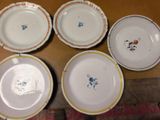 six white plates with blue and yellow designs on them sitting on a table
