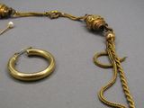 un collier en or et une bague en or posés sur une table