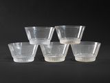 six clear glass cups sitting on top of a black surface