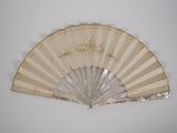 a white fan with a gold design on it