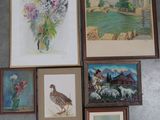 de nombreux tableaux représentant des oiseaux et des fleurs accrochés au mur