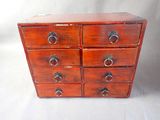 une petite commode en bois sur fond blanc