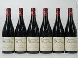 six bouteilles de vin rouge sont alignées sur une table