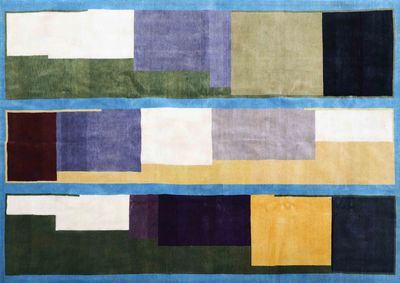 a blue rug with multicolored squares and squares on it