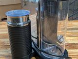 a coffee maker and a cup on a table