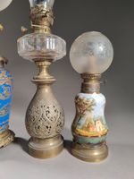 Réunion de quatre lampes à pétrole en régule ou porcelaine. (photo 2)
