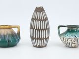 three different vases sitting next to each other on a white surface