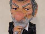 a figurine of a man in a suit with a ring on his finger