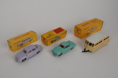 Quatre petites voitures sont posées les unes à côté des autres sur une surface blanche.