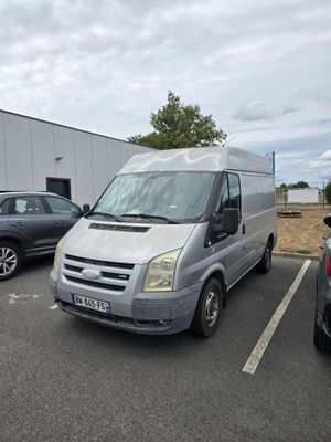une camionnette argentée garée sur un parking à côté d'autres voitures