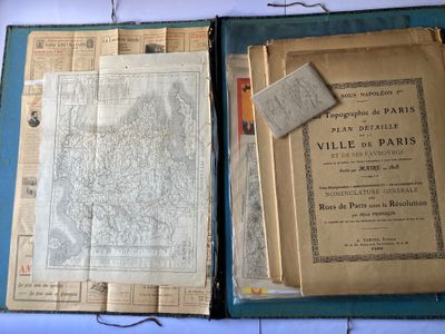 un vieux livre ouvert, dévoilant une carte de Paris et une carte de Paris