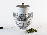 un vase blanc orné d'un motif noir et blanc