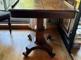 a wooden table with a black chair in front of a window