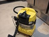 un aspirateur jaune posé par terre dans la cuisine