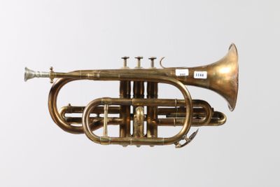 a brass trumpet that is sitting on a white surface