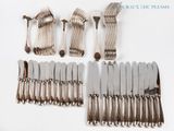 a lot of silverware on a white table